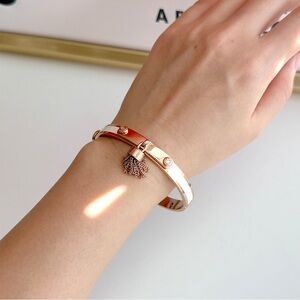 henri bendel Rose Gold and White Enamel Hinged Bangle Bracelet with Tassel Charm